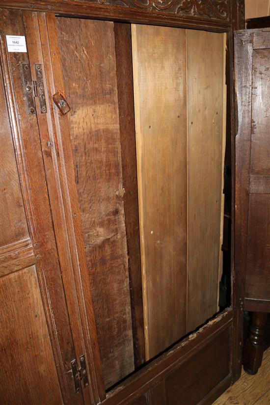 A 17th century oak carved and panelled two door hanging cupboard, W.150cm (a.f.)